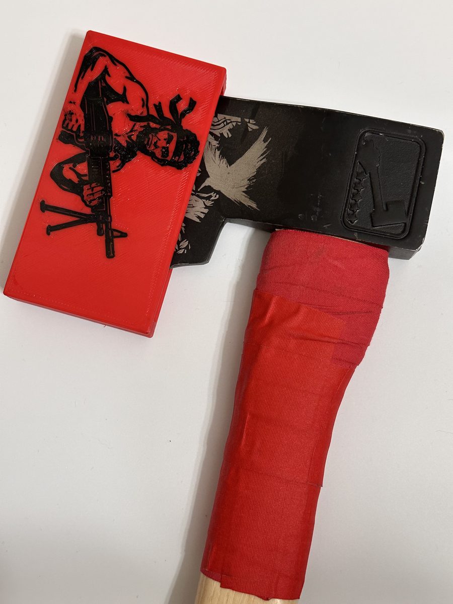 Rambo custom red sheath drawn part way off a competition hatchet, showing the fit